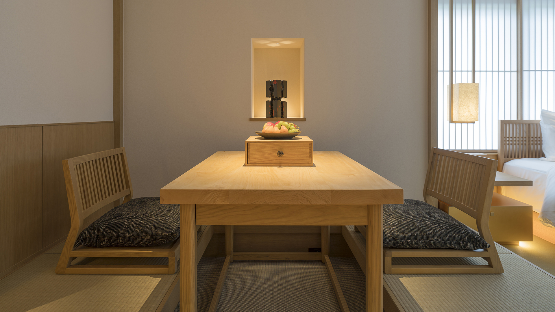 Low table with fruit bowl, flanked by cushions, in a serene Banyan Tree Higashiyama Kyoto room.